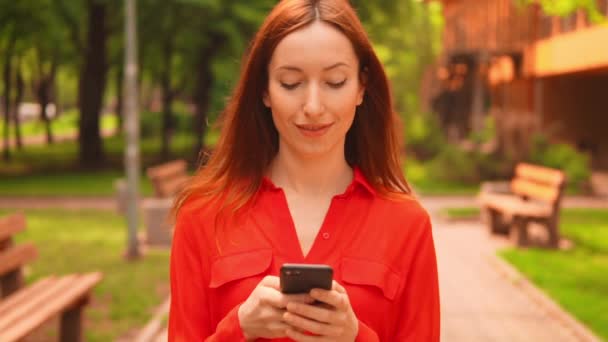 Primer plano cara caucásico hembra chateando en línea usando móvil al aire libre — Vídeos de Stock