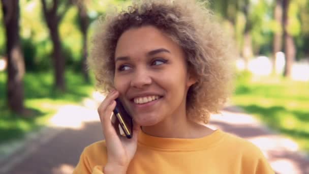 Cheerful female with cell phone walk on the street — Stock Video