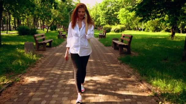 Frau spricht zu Fuß per Smartphone — Stockvideo