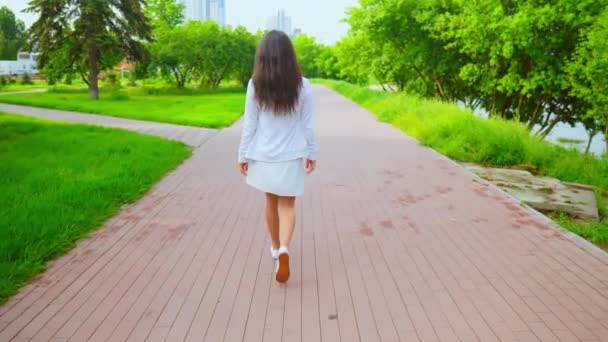 Caucasiano menina vestindo vestido branco desfrutar de sua caminhada — Vídeo de Stock