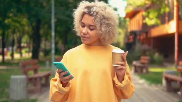 Alegre hembra celebración smartphone en la ciudad — Vídeos de Stock