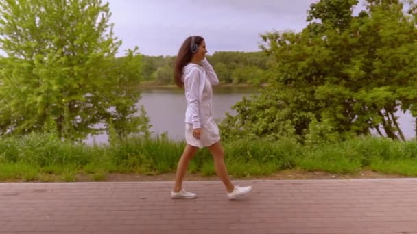 Profil kobieta cieszyć piosenki spacery wzdłuż jeziora — Wideo stockowe