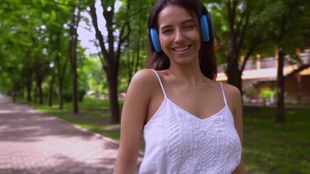 Mujer alegre con auriculares al aire libre — Vídeo de stock