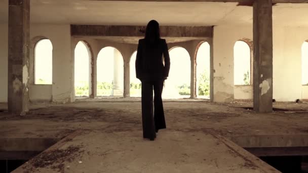 Unrecognizable brunette walks in forsaken building — Stock Video