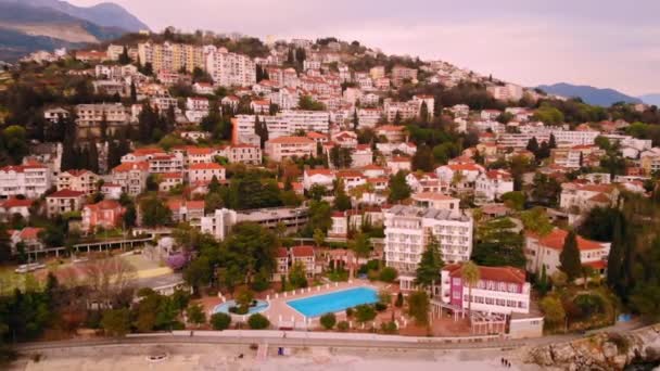 Drone volando sobre la ciudad en la orilla del mar — Vídeos de Stock