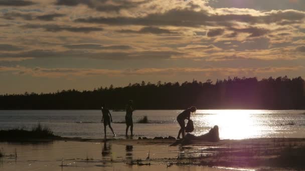 Семья наслаждается закатом на озере — стоковое видео