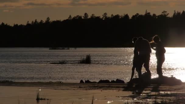 Familjen njuta av solnedgången vid sjöstranden i Kanada — Stockvideo