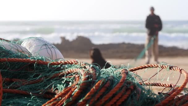 Ένας ψαράς στο παρασκήνιο defocused επισκευή ένα Ωκεανό δίχτυ αλιείας στο Μαρόκο αργή κίνηση — Αρχείο Βίντεο