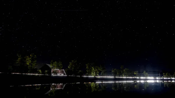 Kanada'da bir Gölü ile kırmızı bir ahır ve arabalar geçen ışıklar gece çekimi