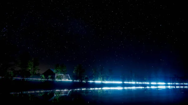 カナダの湖と赤い納屋そして車を渡すことからのライトからの夜景 — ストック写真