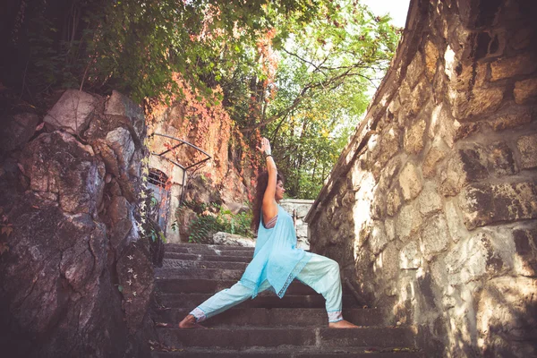 Женщина практиковать йогу на старой лестнице на открытом воздухе — стоковое фото