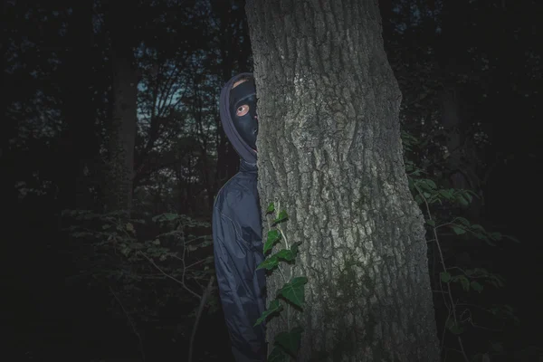 Mann mit schwarzer Maske im Wald — Stockfoto