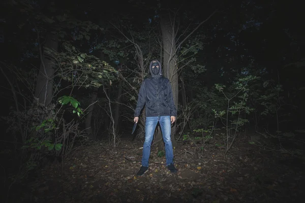 Hombre con máscara y cuchillo en la madera — Foto de Stock