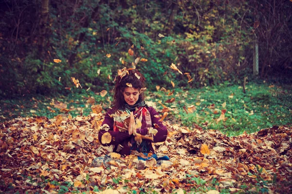 Mulher na posição de lótus ioga em folhas de outono — Fotografia de Stock