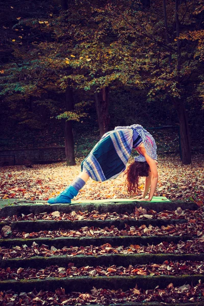 Mujer joven practica yoga al aire libre — Foto de Stock