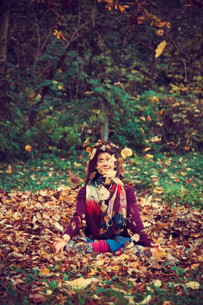 Donna in posizione loto yoga in foglie di autunno — Foto Stock