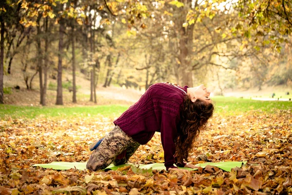 Vrouw praktijk yoga die zich uitstrekt buiten — Stockfoto