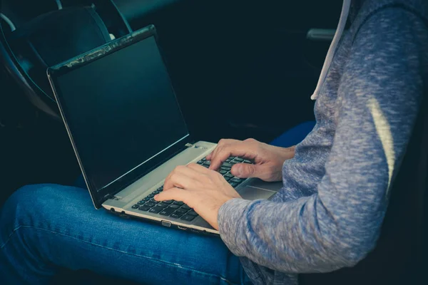 Hacker sentarse en el coche con su computadora portátil — Foto de Stock