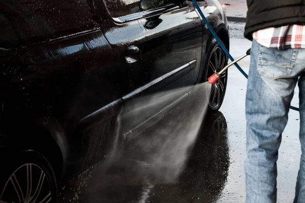Człowiek, mycia samochodu z myjki ciśnieniowej — Zdjęcie stockowe