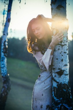 Huş ağacı tarafından gün batımında güzel kız