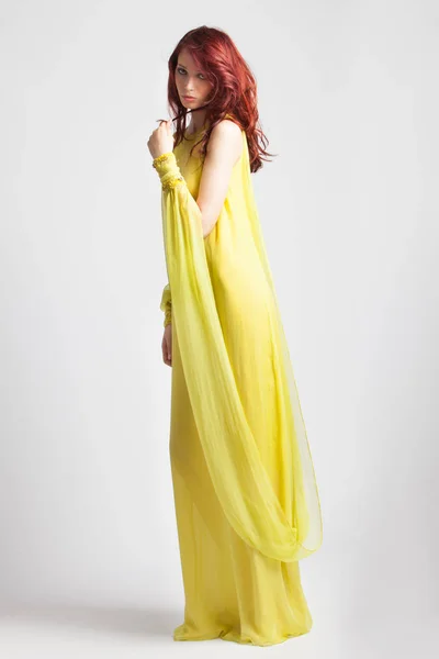 Vörös hajú lány hosszú elegáns sárga ruha — Stock Fotó