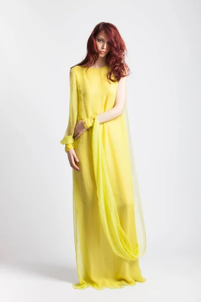 Vörös hajú lány hosszú elegáns sárga ruha — Stock Fotó