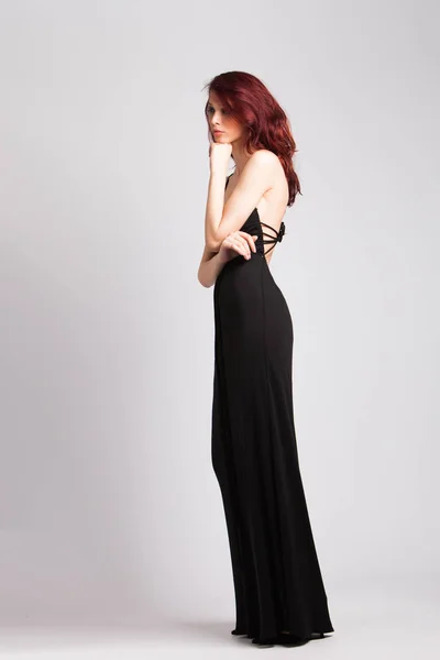Vörös hajú lány hosszú fekete estélyi ruhában — Stock Fotó