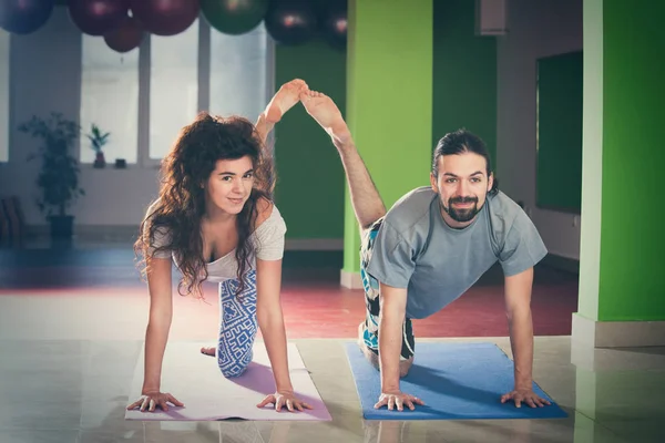 Joven hombre y mujer haciendo yoga indoor —  Fotos de Stock