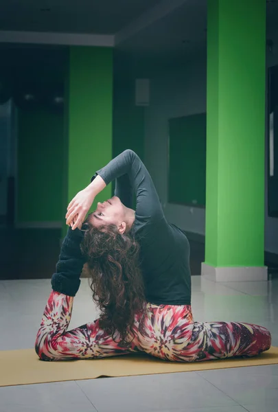 Passar ung kvinna gör yoga inomhus — Stockfoto