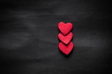 three red hearts on black paper  clipart