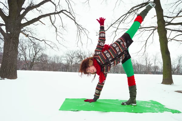 Щаслива молода жінка робить йогу на снігу в парку — стокове фото