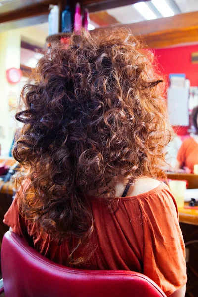 Woman with long curly hair at hairdresser — Stock Photo, Image