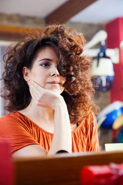 Giovane donna con lunghi capelli ricci in studio di capelli — Foto Stock