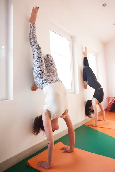 Two young woman doing handstand indoor — Stock Photo, Image