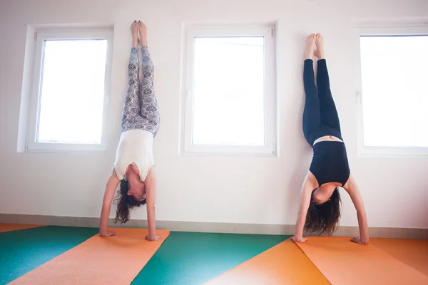 Zwei junge Frauen beim Handstand in der Halle — Stockfoto