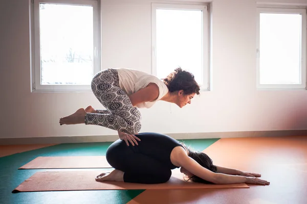 Två unga kvinnor gör yoga inomhus — Stockfoto