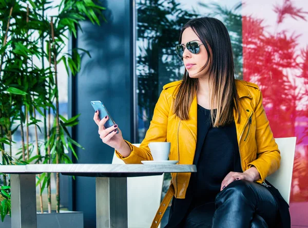 Міська дівчина сидить у кафе на відкритому повітрі концепція міського життя — стокове фото