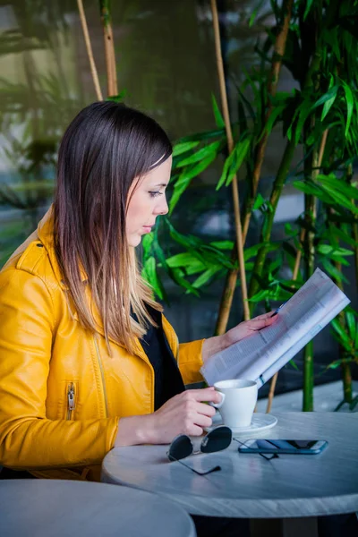 Young woman sit in cafe outdoor reading magazine — Stock Photo, Image