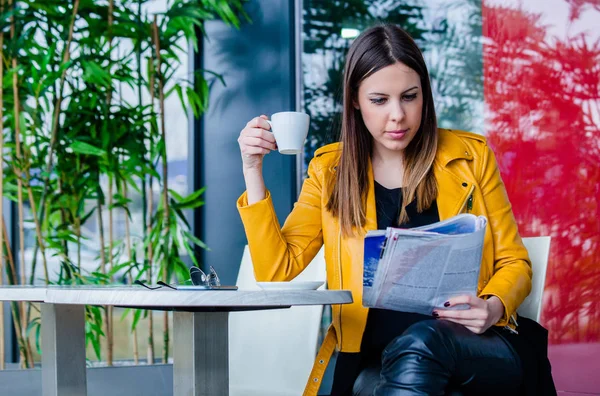 Young woman reading magazine in cafe outdoor — Stock Photo, Image