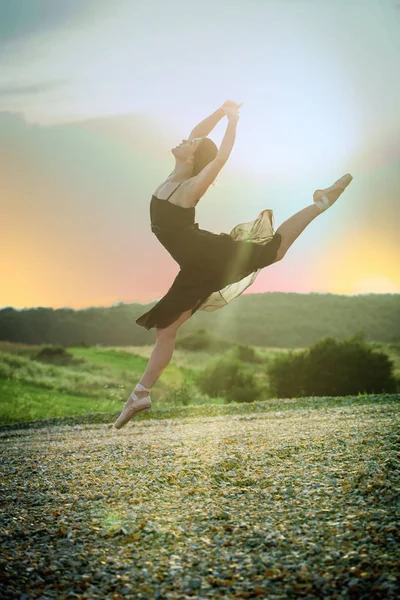 Танцовщица прыгает на закате — стоковое фото
