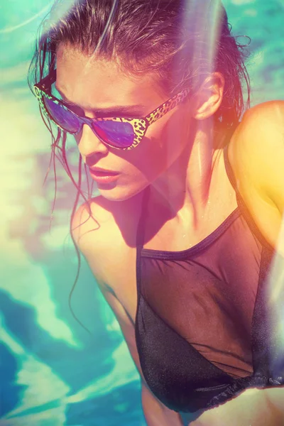Menina atraente em biquíni e óculos de sol na piscina — Fotografia de Stock