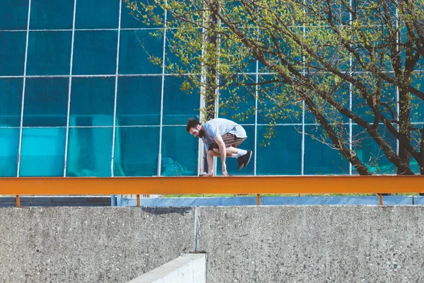 Joven haciendo parkour en la ciudad — Foto de Stock