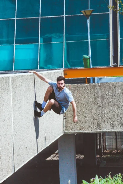 Mladý muž dělá parkour ve městě — Stock fotografie