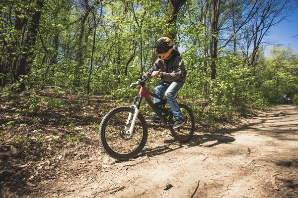 Joven montar en bicicleta de montaña a través del bosque — Foto de Stock