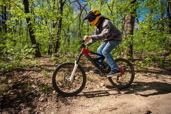 Joven montar en bicicleta de montaña a través del bosque — Foto de Stock