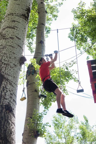 Muž v dobrodružství parku na vrcholu stromu — Stock fotografie