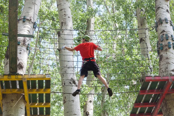 Homem no parque de aventura no topo da árvore — Fotografia de Stock