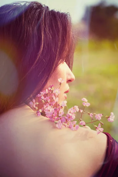 Ung kvinna porträtt med blommor utomhus tillbaka — Stockfoto