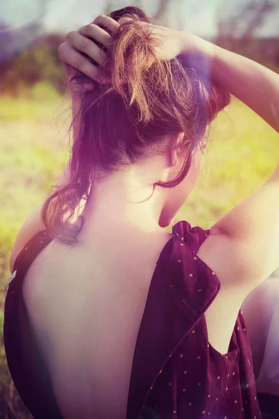 Fille avec les mains dans les cheveux vue arrière en plein air dans le champ — Photo