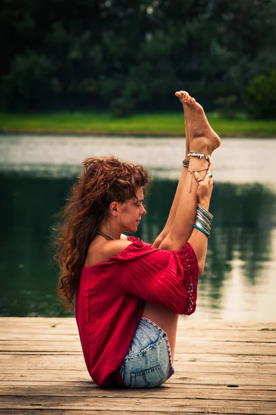 Jeune femme pratique le yoga au bord du lac — Photo